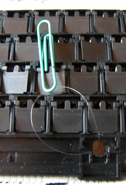 Wire looped through the hole, paperclip to keep it in place