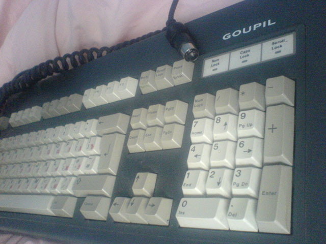 this is a length shot of the keyboard showing the AT cable and goupil logo.